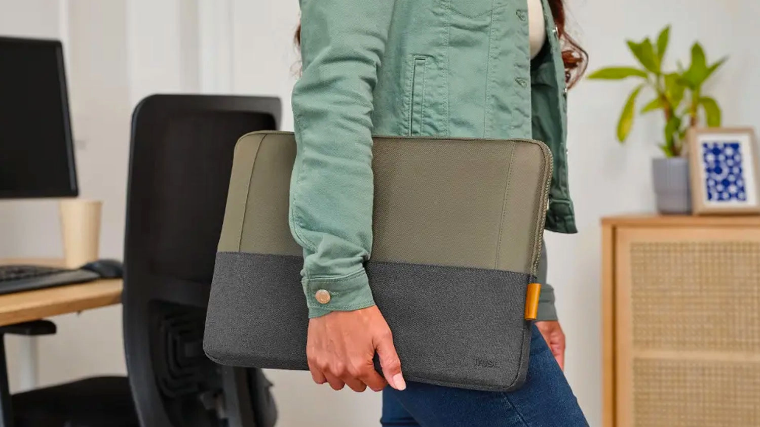 Žena prenáša notebook v obale Trust Lisboa Laptop Sleeve 16