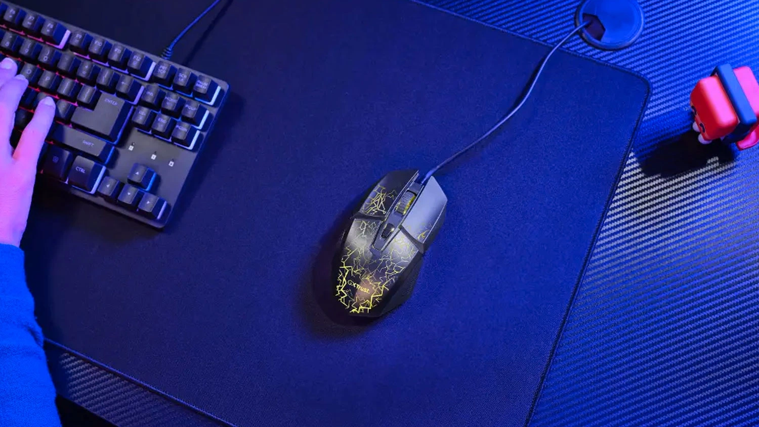 Hern&aacute; my&scaron; Trust GXT 113 Felox Illuminated na stole vedľa kl&aacute;vesnice