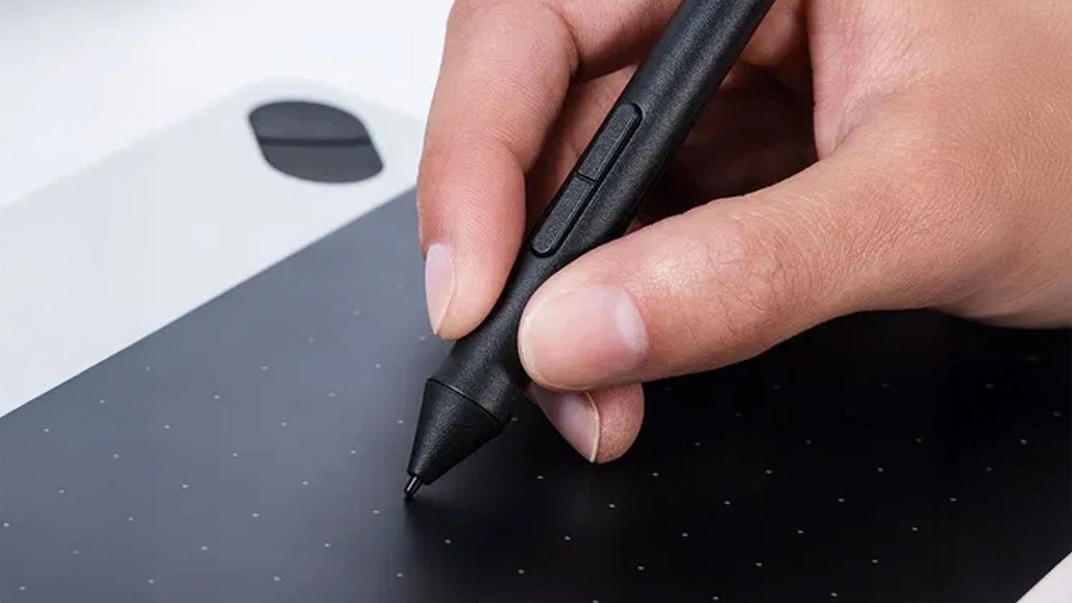Ruka drž&iacute; n&aacute;hradn&iacute; pero a pracuje na tabletu