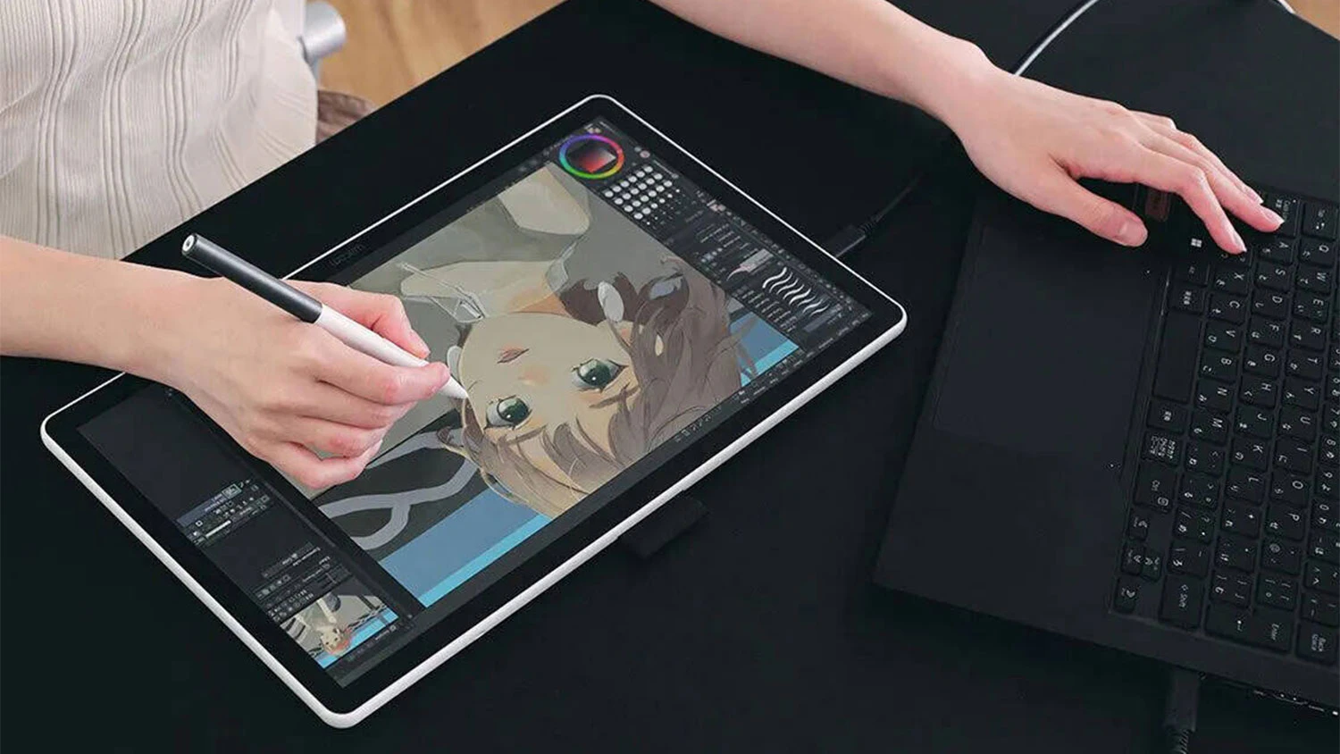 Osoba u stolu s notebookem a tabletem Wacom One 14