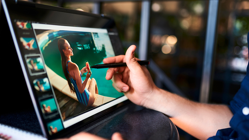 Muž upravuje fotografie pomocí dotykové pera na konvertibilním notebooku_03