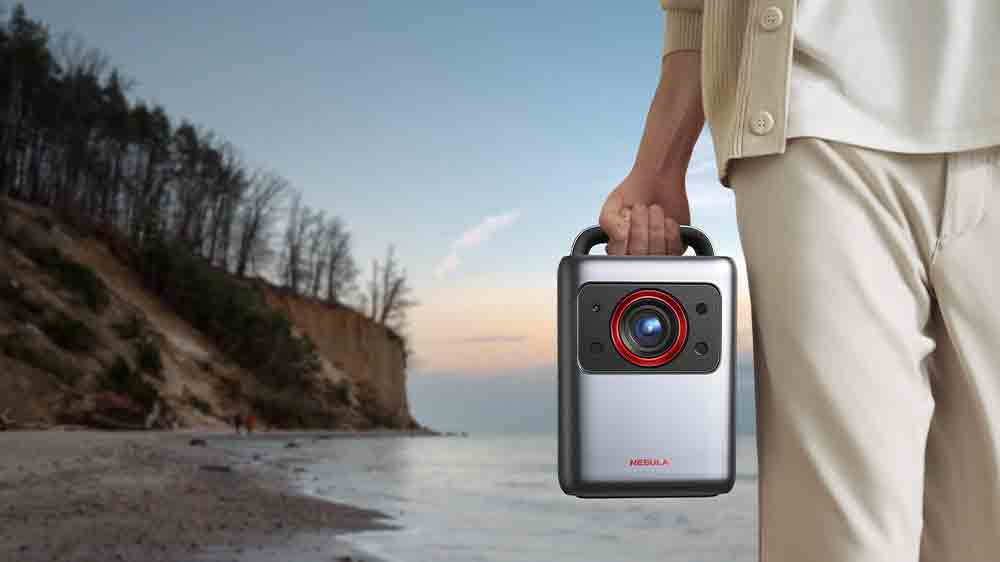 Človek nesie v ruke projektor Anker Nebula Cosmos Laser 4K