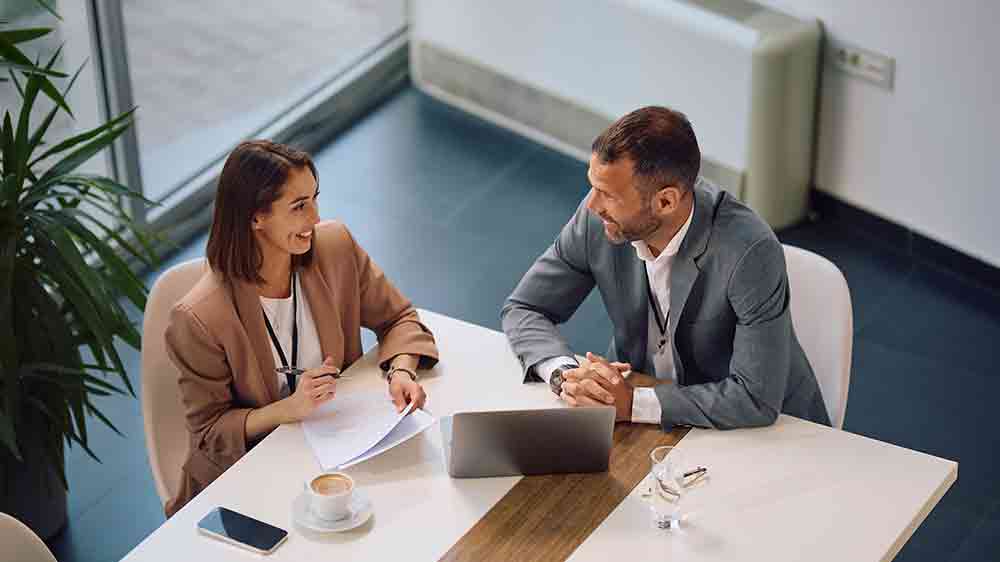 Žena a muž sedící u stolu během obchodního jednání_02