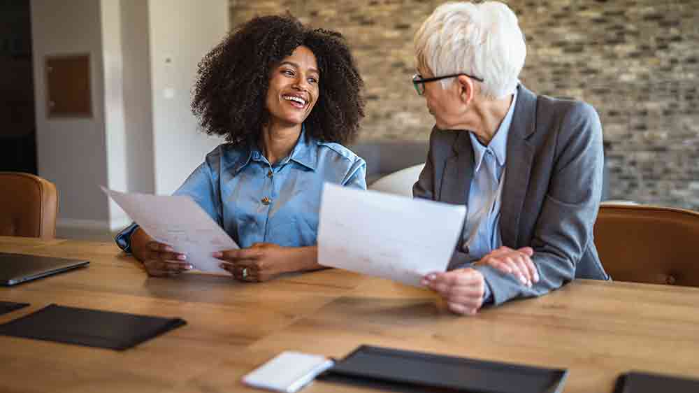 Dva lidé držící papíry v ruce sedí u stolu_03