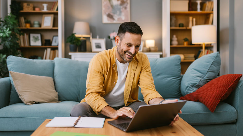 Mladý muž pracující na notebooku Asus ExpertBook B3 B3404CVA v obývacím pokoji_02
