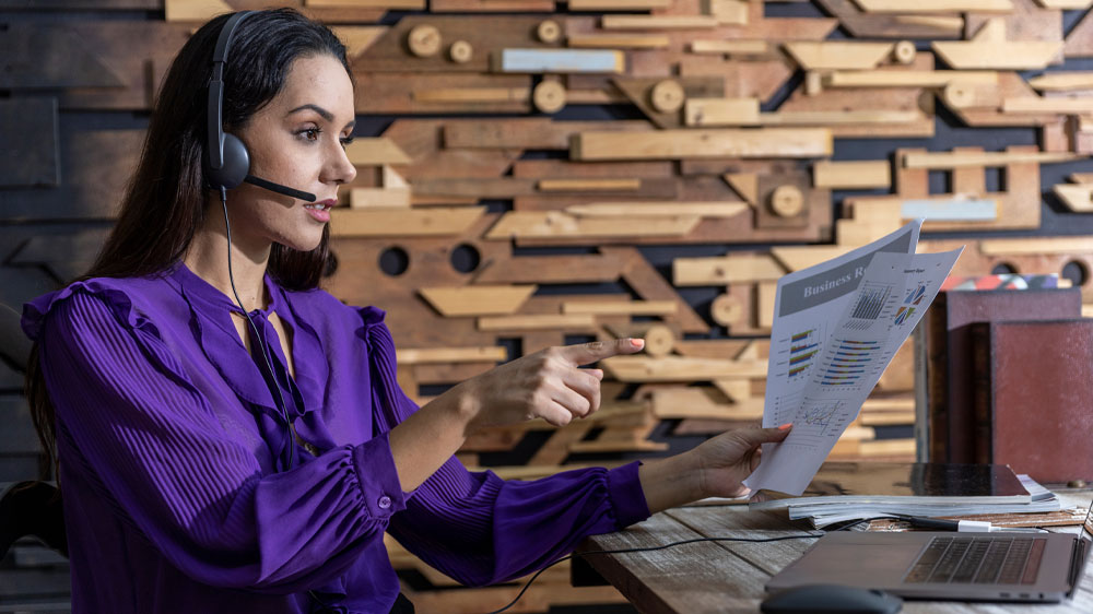 Mladá žena v kanceláři se sluchátky na uších pracující na notebooku Asus ExpertBook B3 B3404CVA v obývacím pokoji_04