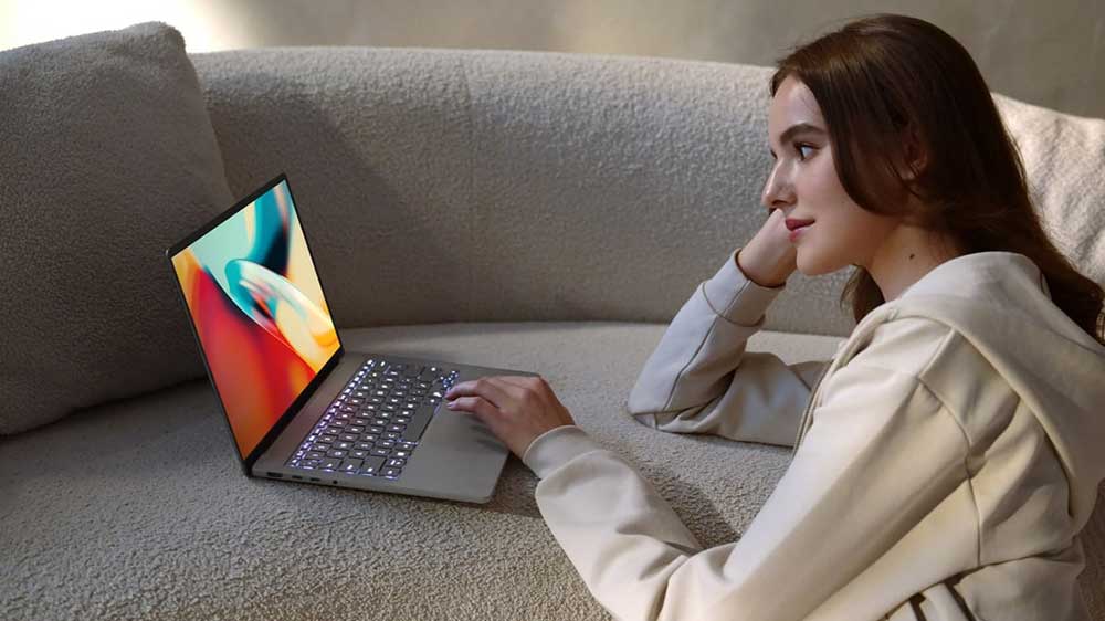Žena na pohovce sledující ASUS Zenbook A14_03