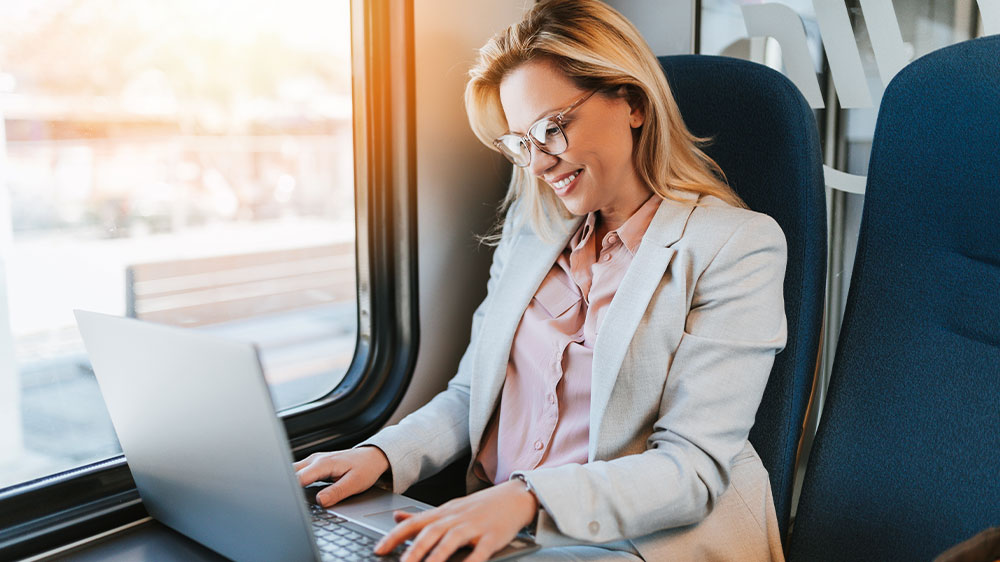 Žena pracuje na notebooku během cesty vlakem_02