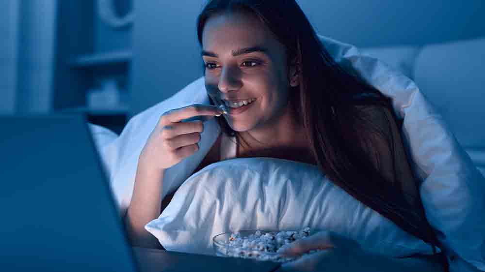 Žena v posteli kouká na film na notebooku_04