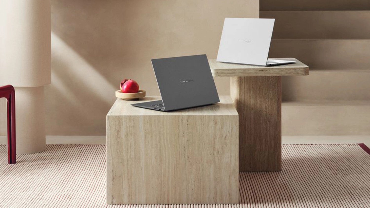 Pokoj s modern&iacute;m n&aacute;bytkem a stolky s notebooky ASUS