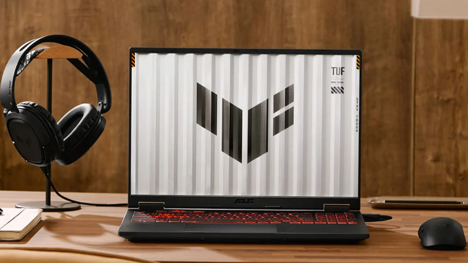 Notebook ASUS TUF Gaming A18 so sl&uacute;chadlami na stole