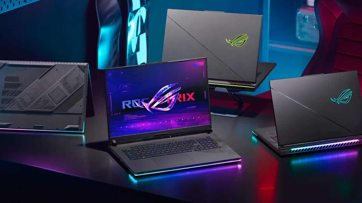 Herní stůl s rozloženými notebooky ASUS