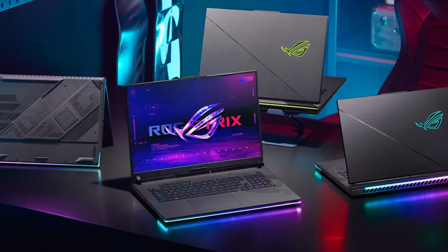 Herní stůl s rozloženými notebooky ASUS