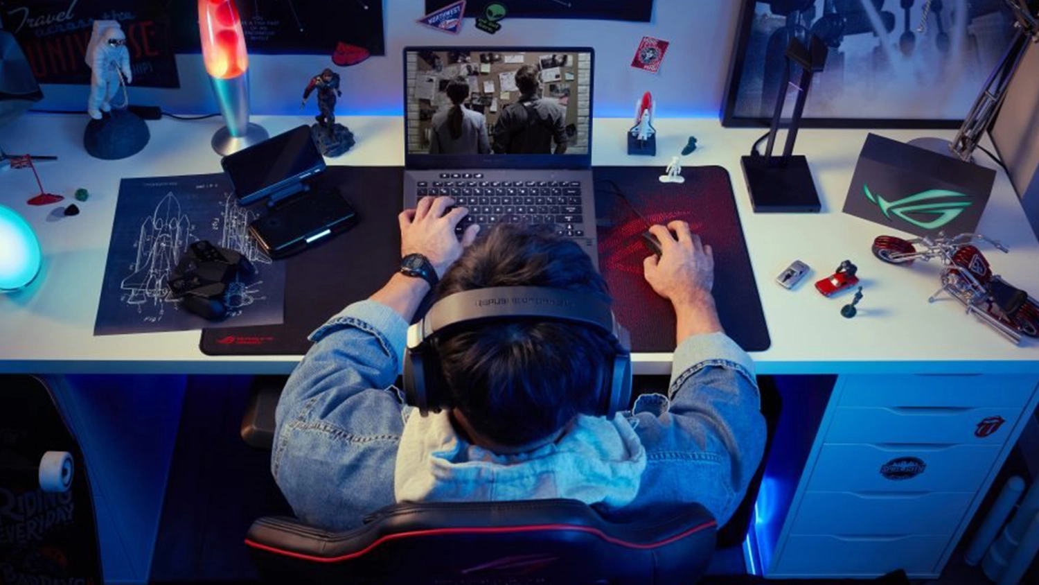 Osoba hrající u stolu hry na notebooku ASUS