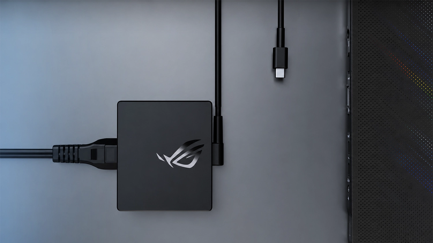 Adapt&eacute;r ASUS ROG 100W USB-C na stole vedle notebooku