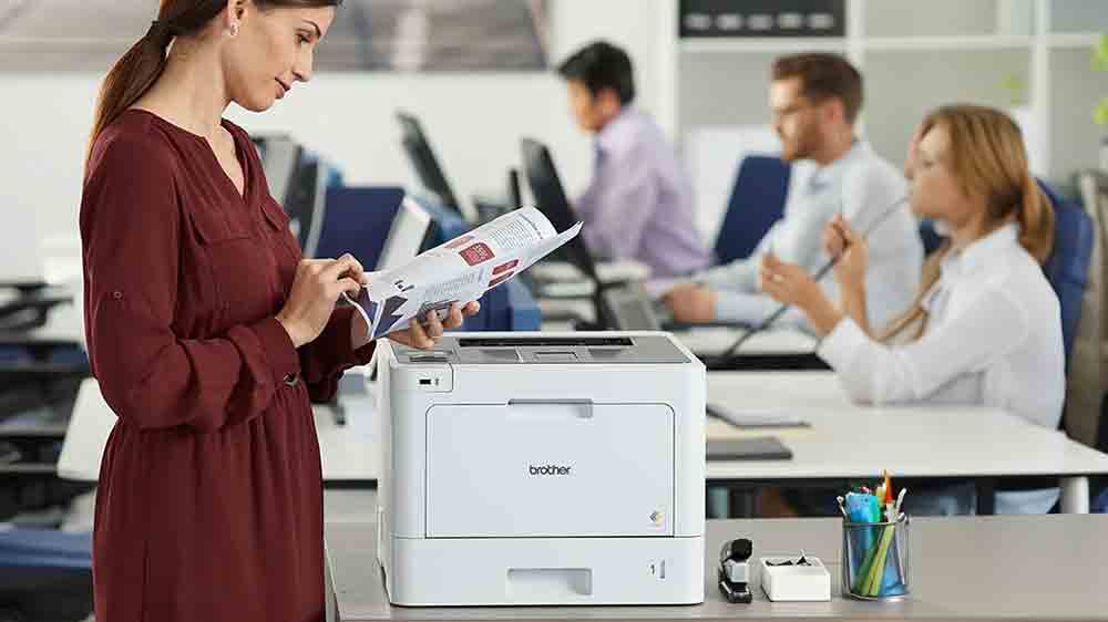 Žena procházející vytištěné papíry u tiskárny Brother HL-L8260CDW_02