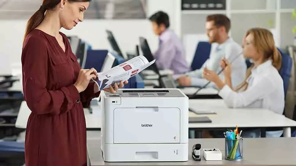 Žena listuje tlačen&yacute;mi papiermi při tlačiarni Brother HL-L8260CDW_02