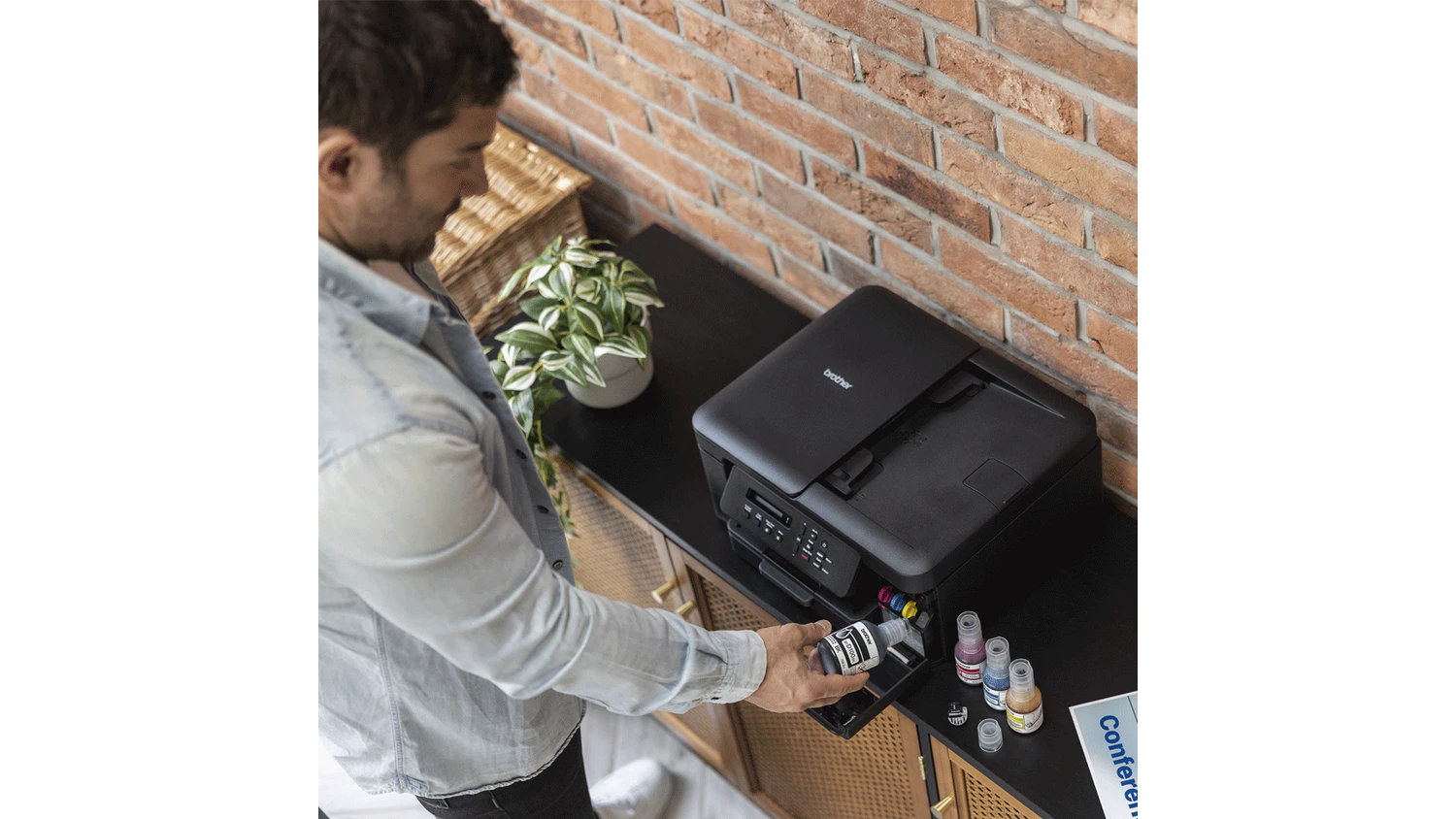 Muž dopĺňa atrament do tlačiarne Brother DCP-T730DW