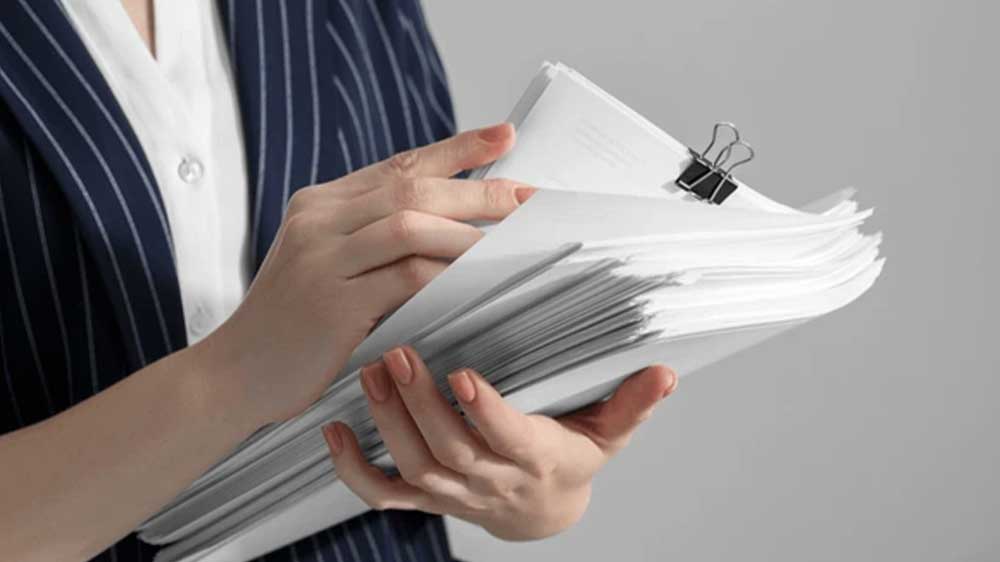 Žena držící v rukou kupu papírů_04