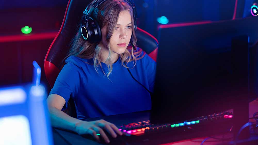 Dívka hrající počítačové hry na RGB podsvícené klávesnici_03