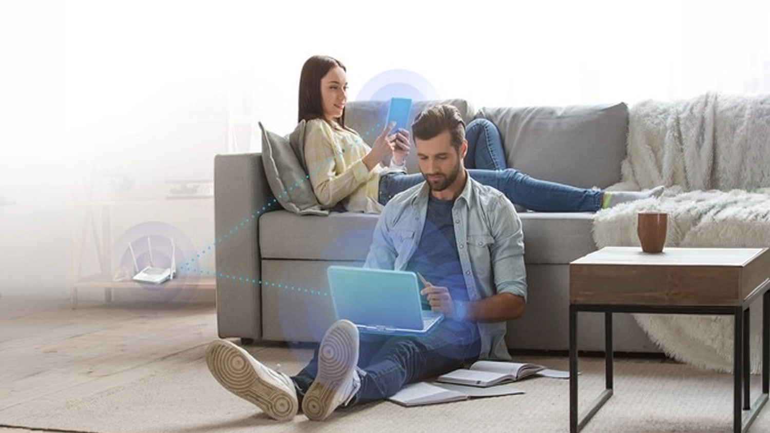 Muž a žena sedí v obýváku a využívají WiFi z routeru D-Link