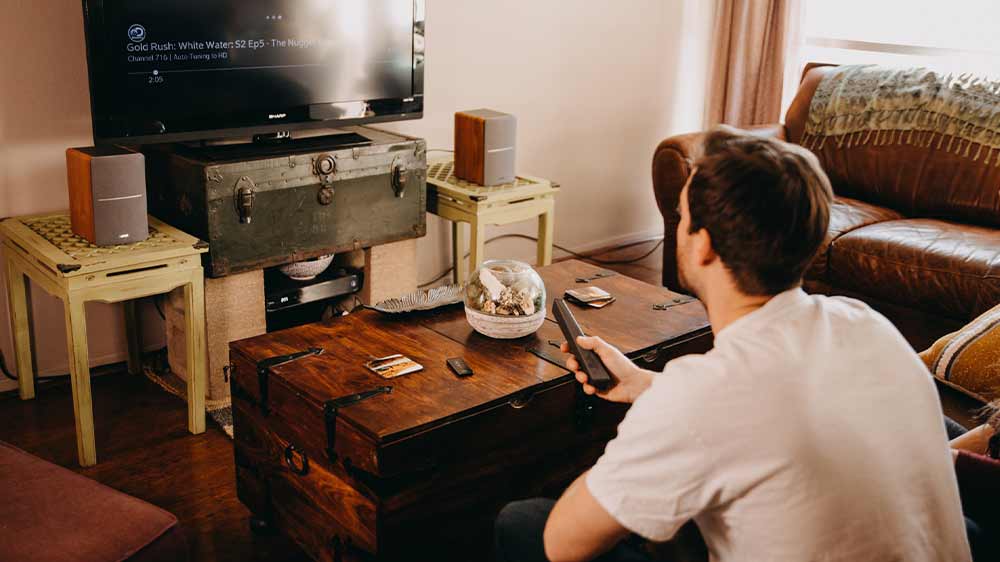 Muž se dívá na televizi s reproduktory Edifier R1280DB_02
