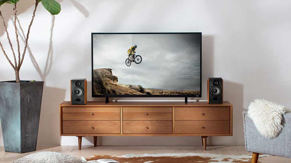 Reproduktory Edifier R1380T 2.0 na skř&iacute;ňce vedle televize v ob&yacute;vac&iacute;m pokoji_02