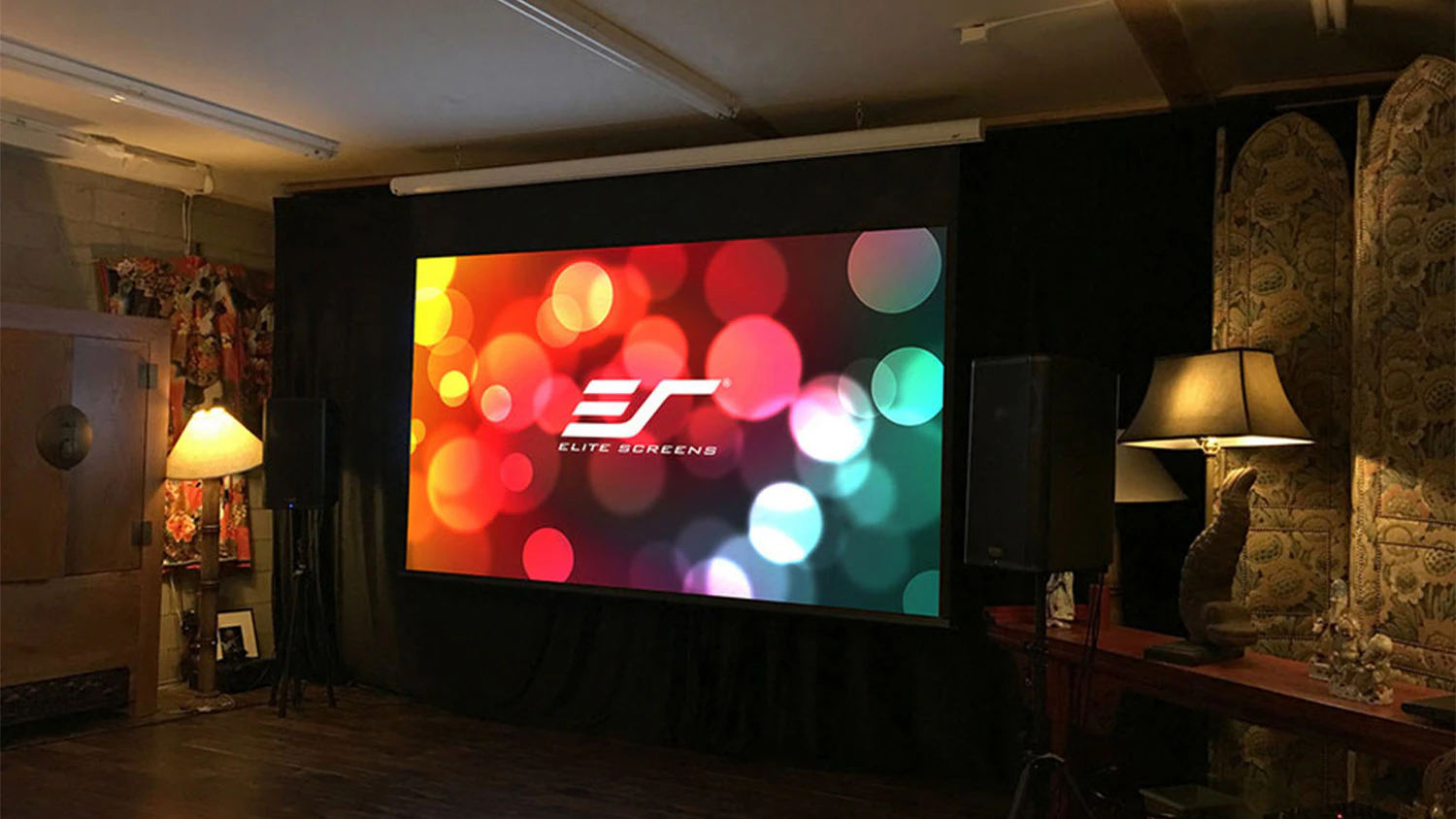 Moderná zatmavená miestnosť s projektorom Elite Screens