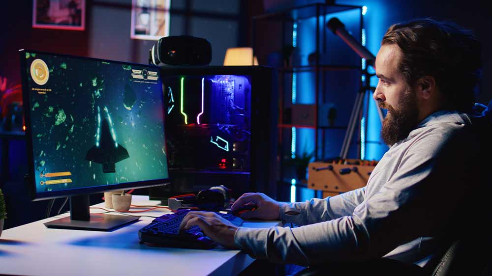 Mladý muž hraje počítačovou hru, používá klávesnici a myš_03