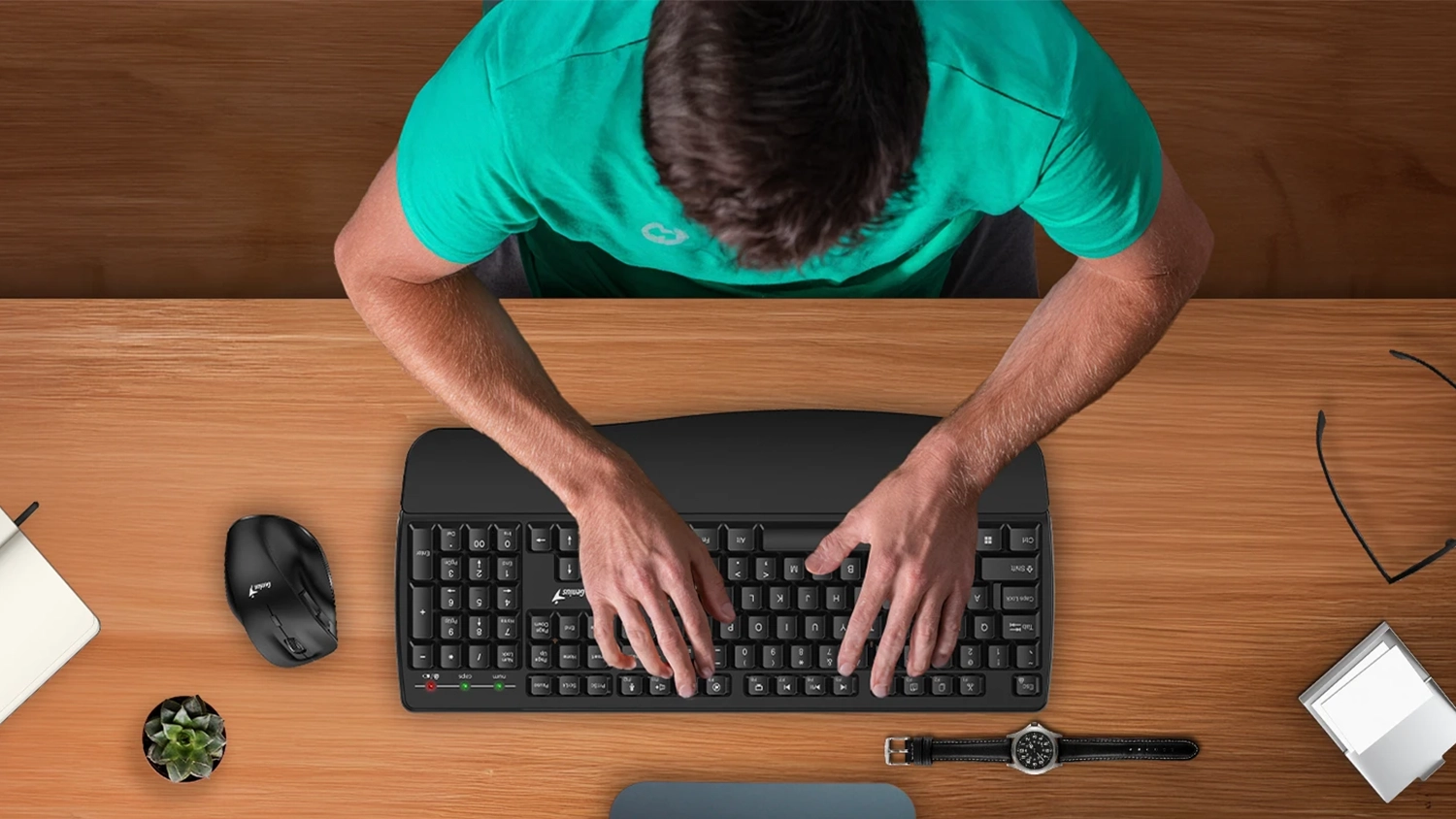 Muž pracuje na klávesnici Genius KB-7123 – horní pohled