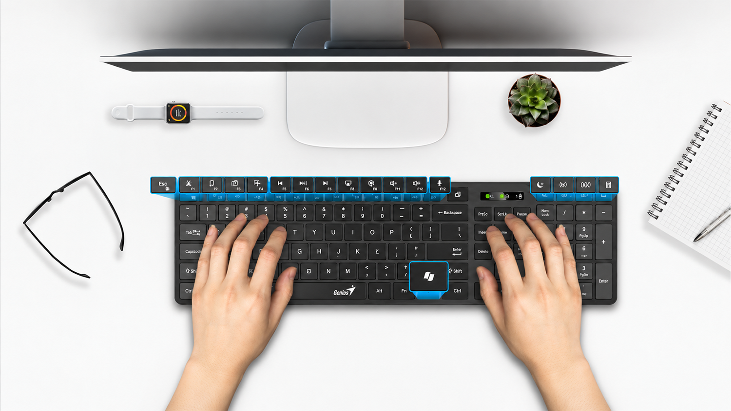 Horní pohled na ruce na pracovním stole, které píší na klávesnici Genius SlimStar 7250BT Copilot