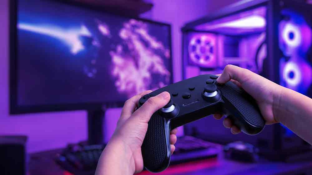 Muž držící gamepad před počítačem _04