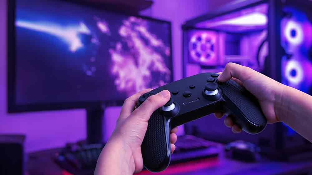 Muž držící gamepad před počítačem _04