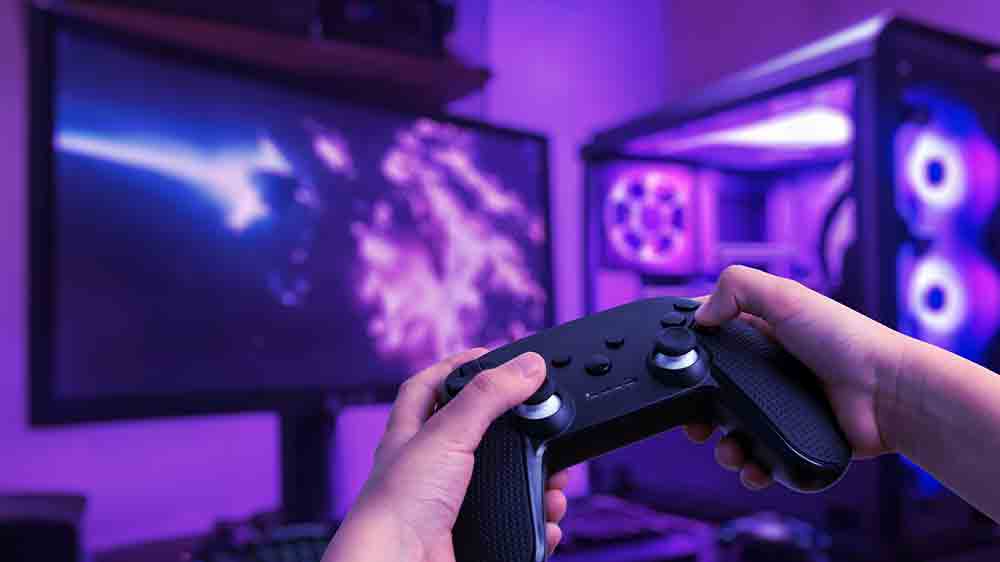 Muž drž&iacute;c&iacute; gamepad před poč&iacute;tačem _04
