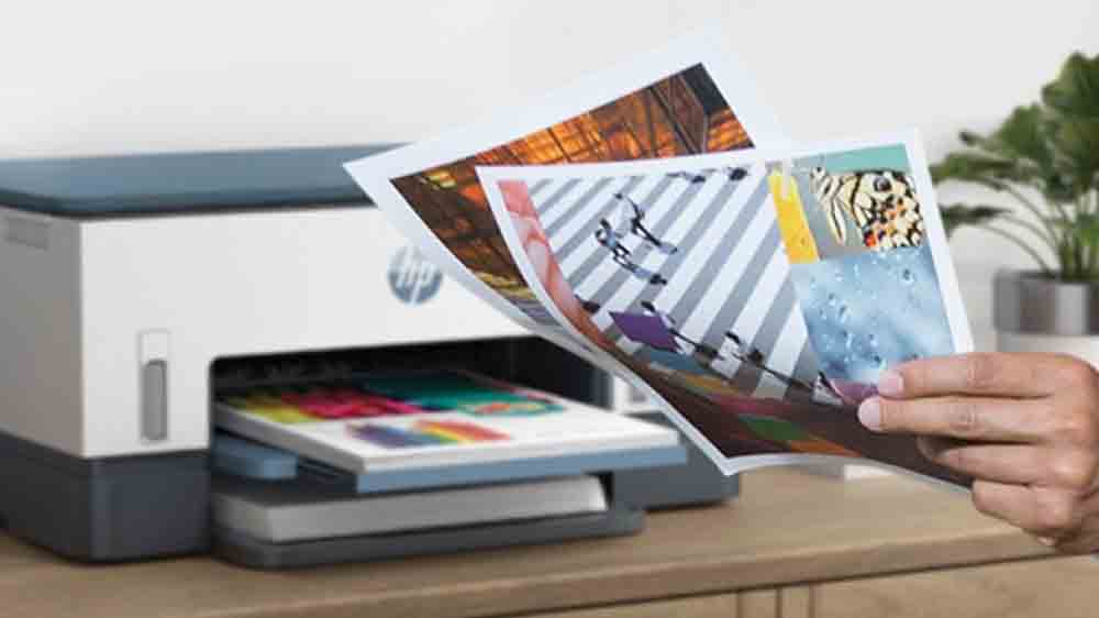 Atramentová tlačiareň HP Smart Tank 720 All-in-One položená na stole s vytlačenými dokumentmi_02