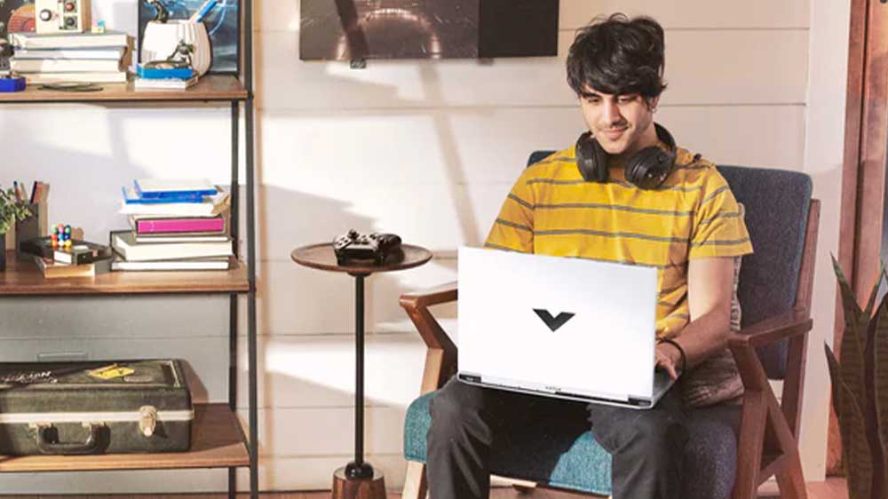 Muž na křesle s notebookem HP Victus Gaming 16-E0070NC_03