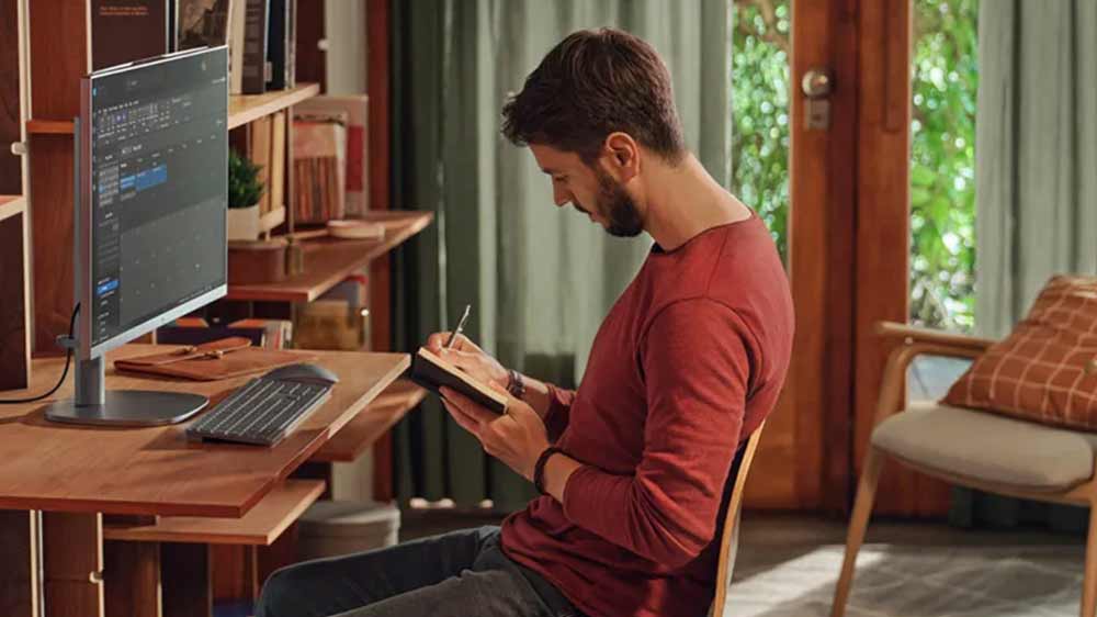 Muž u počítače HP OmniStudio X All-in-One 32-c0002nc píšící zápisky_04