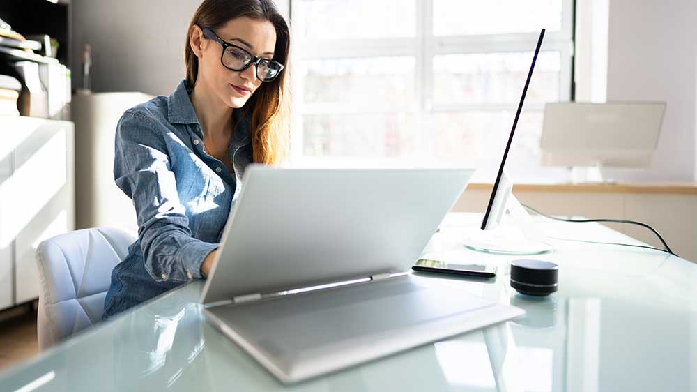 Muž se ženou v kanceláři projednávají smlouvu zobrazenou na displeji notebooku_03