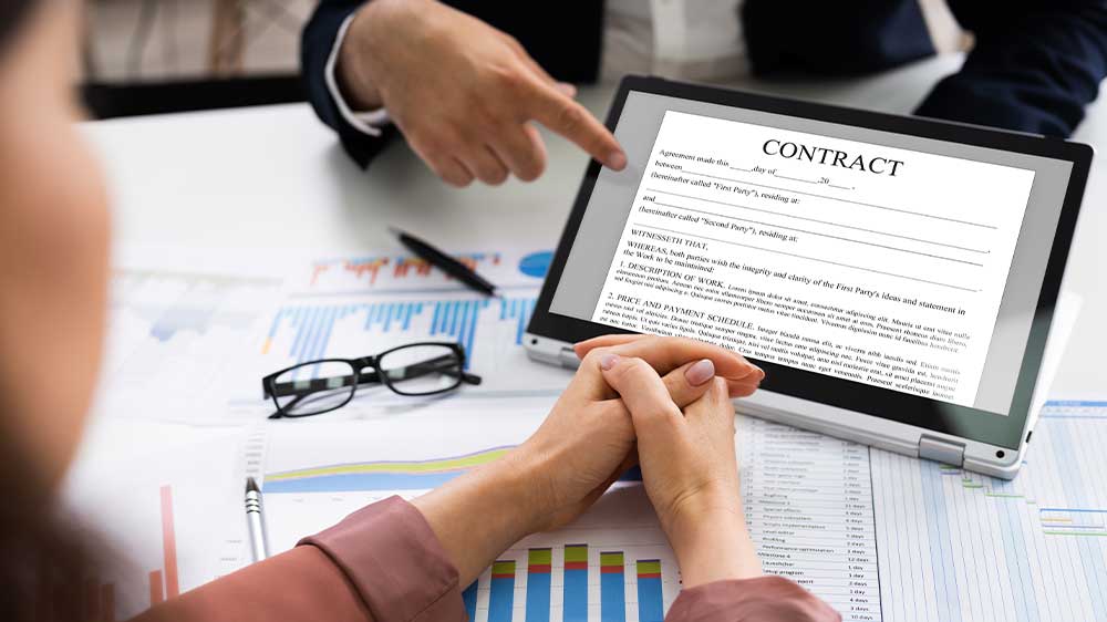 Mladá žena v kanceláři pracuje na notebooku, ke kterému má připojený monitor_06