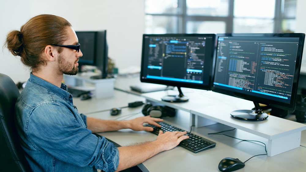 Mladý muž pracuje na počítači a píše na klávesnici_02