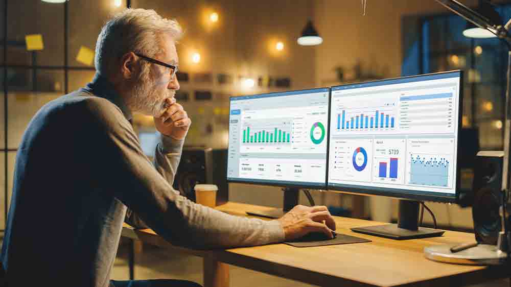 Muž pracuje na počítači s více monitory_04