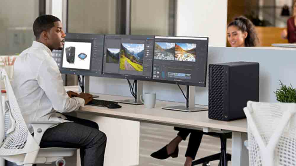 Muž před sestavou monitorů a stoln&iacute;m poč&iacute;tačem HP EliteDesk 8 Tower G1i_02