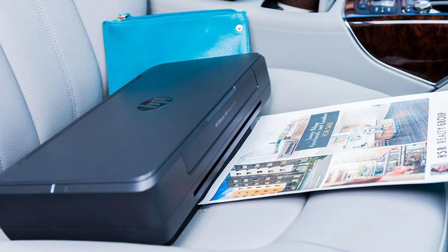 Mobilní tiskárna HP OfficeJet 200 položená v autě na sedačce
