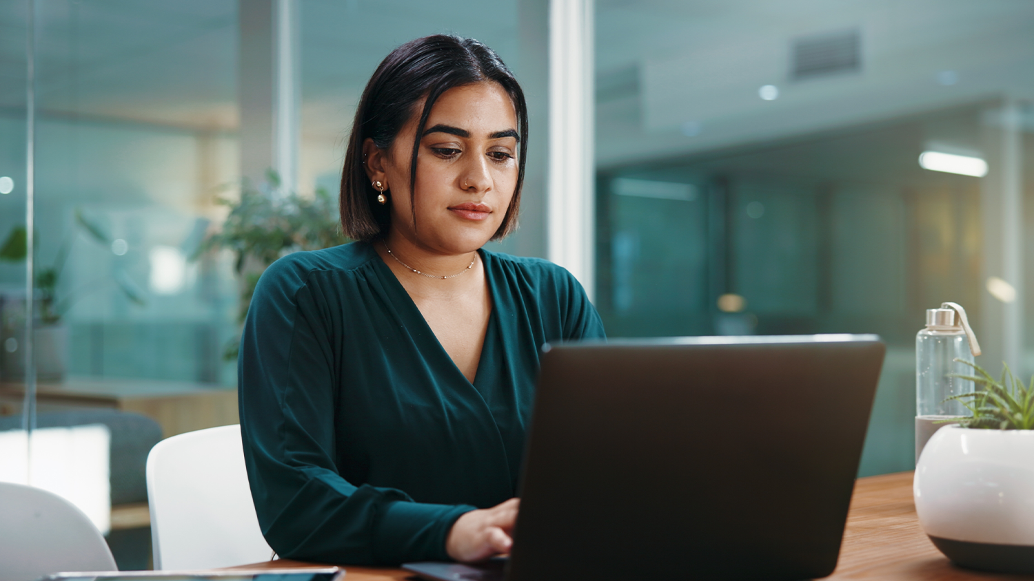 Žena sed&iacute; v kancel&aacute;ři a pracuje na notebooku