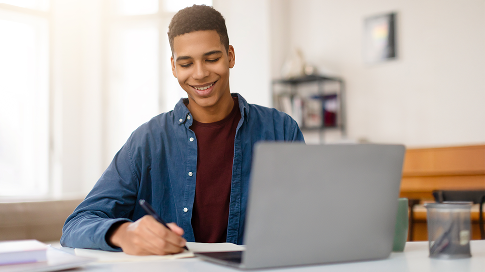 Mlad&yacute; muž sed&iacute; u notebooku