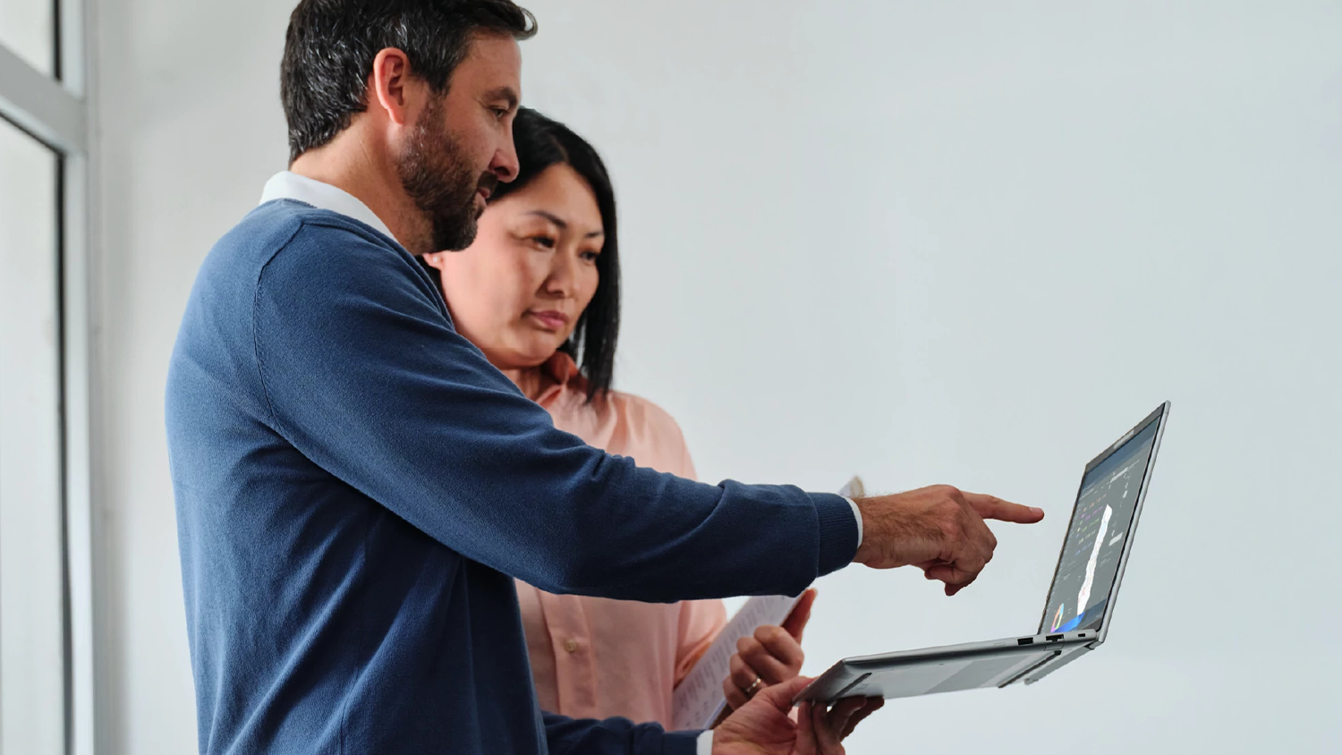 Muž ukazující žene informace na notebooku HP EliteBook 6 G1i