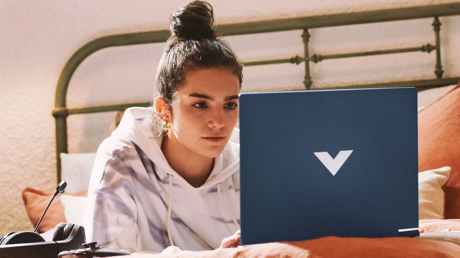 Žena na posteli s notebookem HP Victus