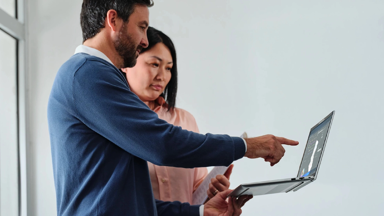 Muž ukazující ženě informace na notebooku HP EliteBook 6 G2a