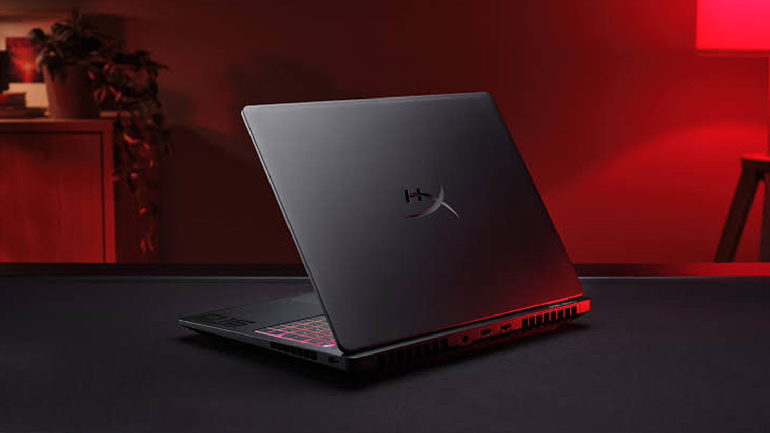 HyperX notebook zezadu na černé podložce v pokoji