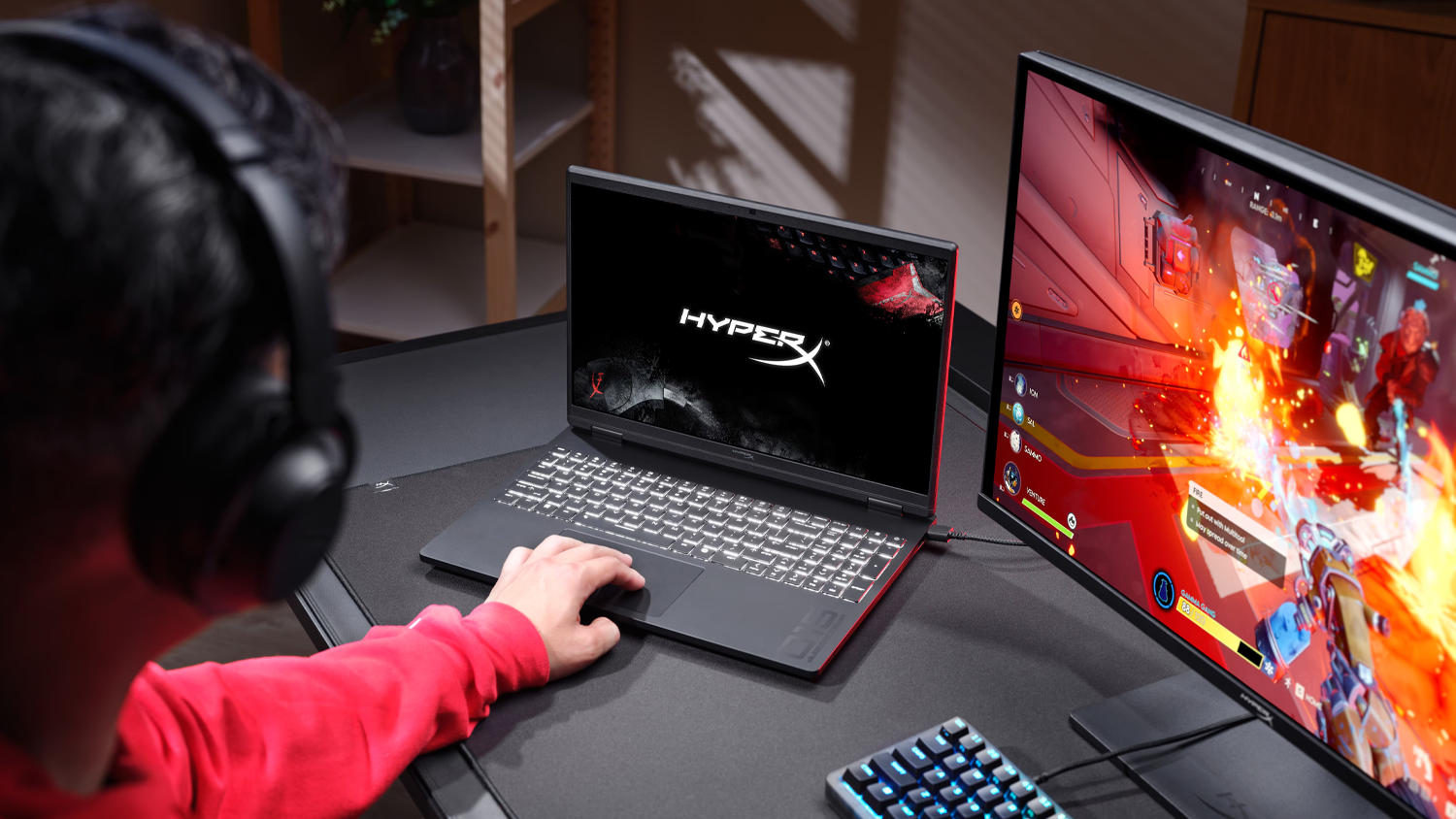 Osoba hrající hru u stolu s notebookem HyperX